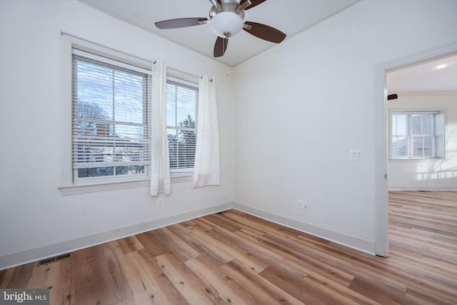 unfurnished room with light wood-type flooring, plenty of natural light, and ceiling fan