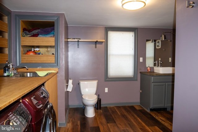 bathroom with washing machine and dryer, vanity, wood-type flooring, and toilet