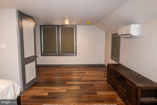 bonus room featuring a wall unit AC, dark hardwood / wood-style flooring, and vaulted ceiling