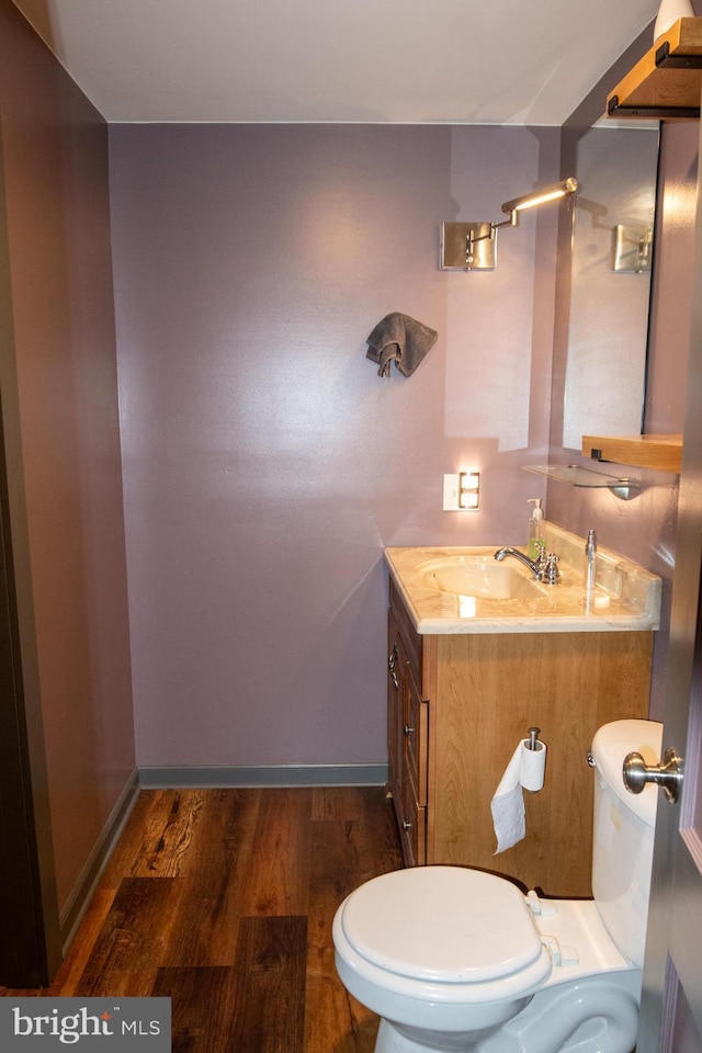 bathroom with hardwood / wood-style floors, vanity, and toilet