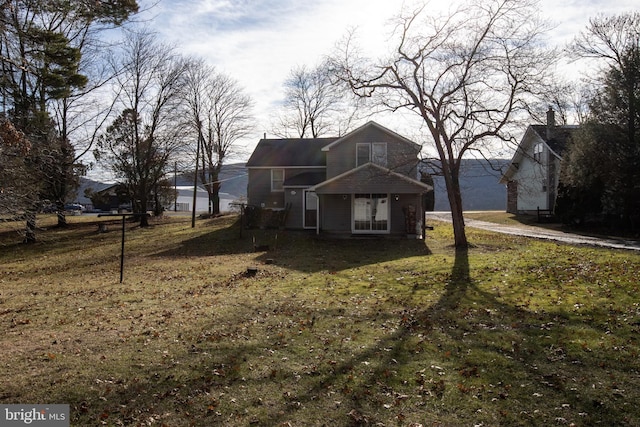 rear view of property featuring a lawn