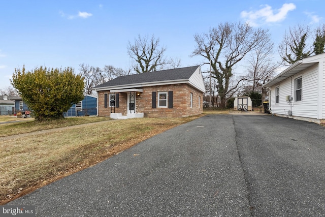 view of front facade with a shed and a front lawn