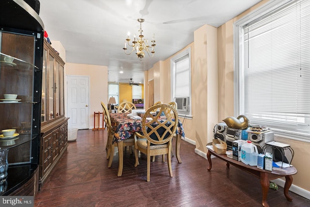 dining room with ceiling fan with notable chandelier and dark hardwood / wood-style flooring