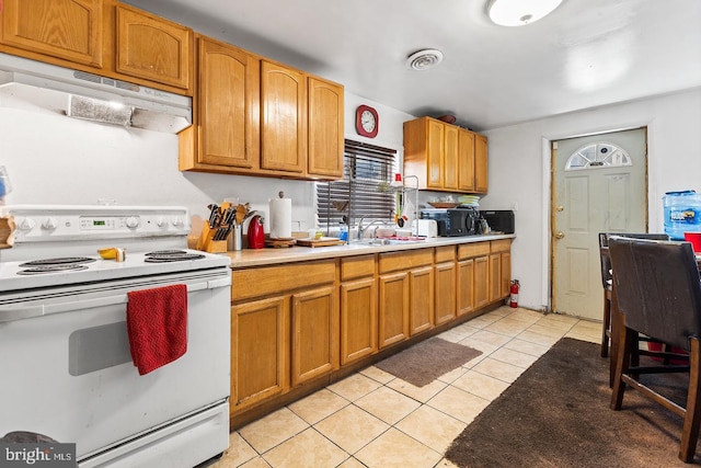 kitchen featuring sink, white range with electric stovetop, and light tile patterned flooring