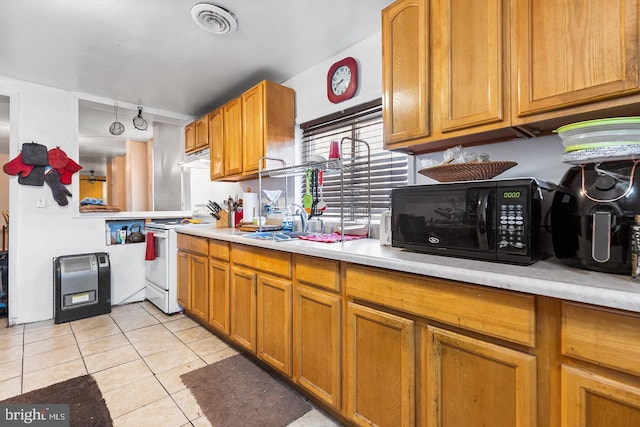 kitchen featuring sink, light tile patterned floors, and white electric stove