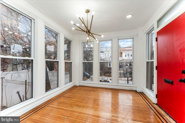 unfurnished sunroom featuring a chandelier