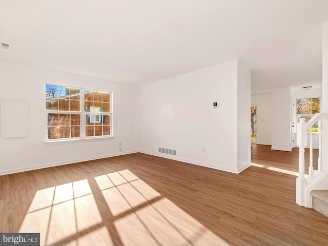 empty room with hardwood / wood-style flooring and a healthy amount of sunlight