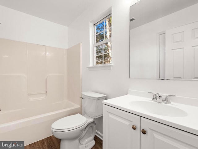 full bathroom with bathing tub / shower combination, hardwood / wood-style floors, vanity, and toilet