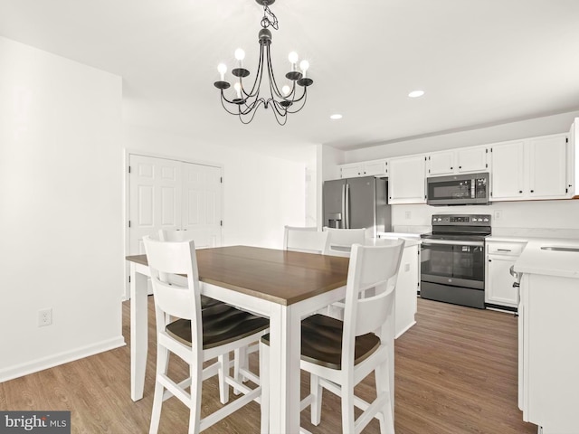 dining room with hardwood / wood-style floors and a notable chandelier