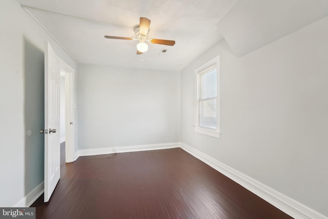 empty room featuring ceiling fan and dark hardwood / wood-style flooring