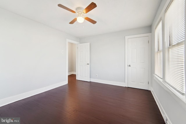 unfurnished bedroom with ceiling fan and dark hardwood / wood-style floors