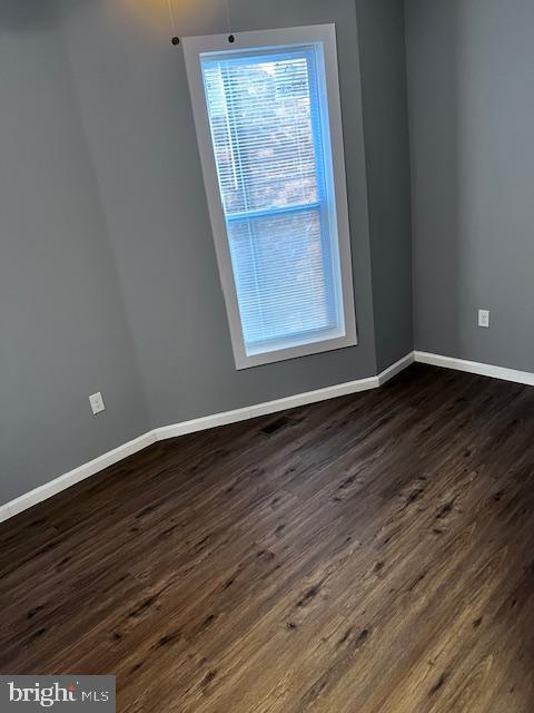 empty room with dark wood-type flooring