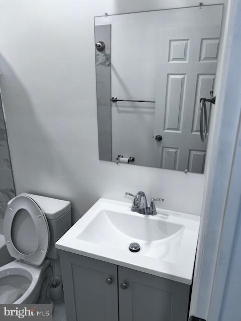 bathroom with a shower, vanity, and toilet