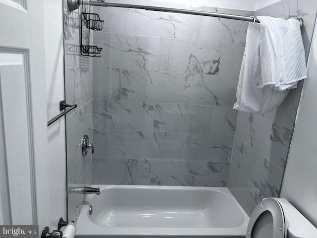 bathroom with shower / bath combination with curtain and toilet