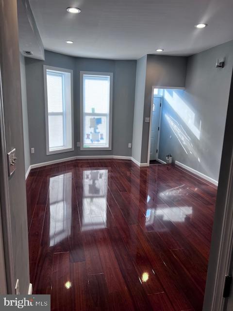 unfurnished living room with dark wood-type flooring