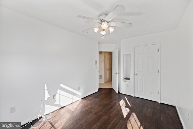 empty room with ceiling fan and dark hardwood / wood-style flooring