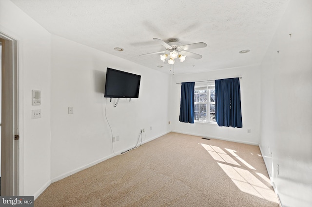 carpeted empty room featuring a textured ceiling and ceiling fan