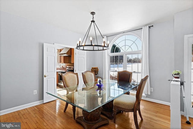 dining space featuring an inviting chandelier and light wood-type flooring