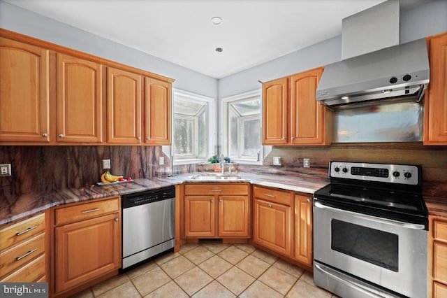 kitchen featuring appliances with stainless steel finishes, sink, wall chimney range hood, light tile patterned flooring, and tasteful backsplash