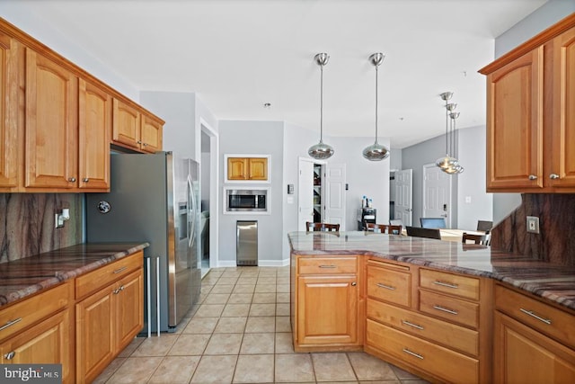 kitchen featuring decorative light fixtures, appliances with stainless steel finishes, light tile patterned floors, and decorative backsplash