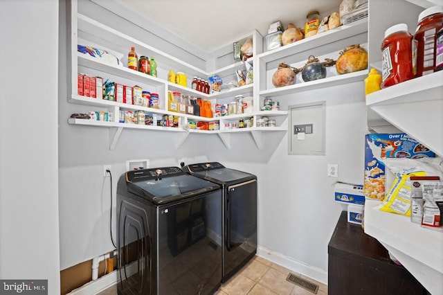 laundry room with washer and clothes dryer and light tile patterned floors