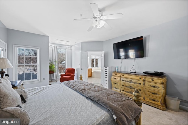 carpeted bedroom featuring ceiling fan and ensuite bath