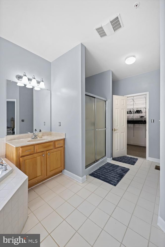 bathroom with vanity, tile patterned floors, and plus walk in shower