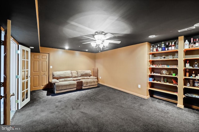 unfurnished room featuring ceiling fan and dark colored carpet