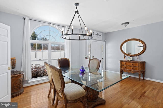 dining space featuring light hardwood / wood-style floors and a notable chandelier