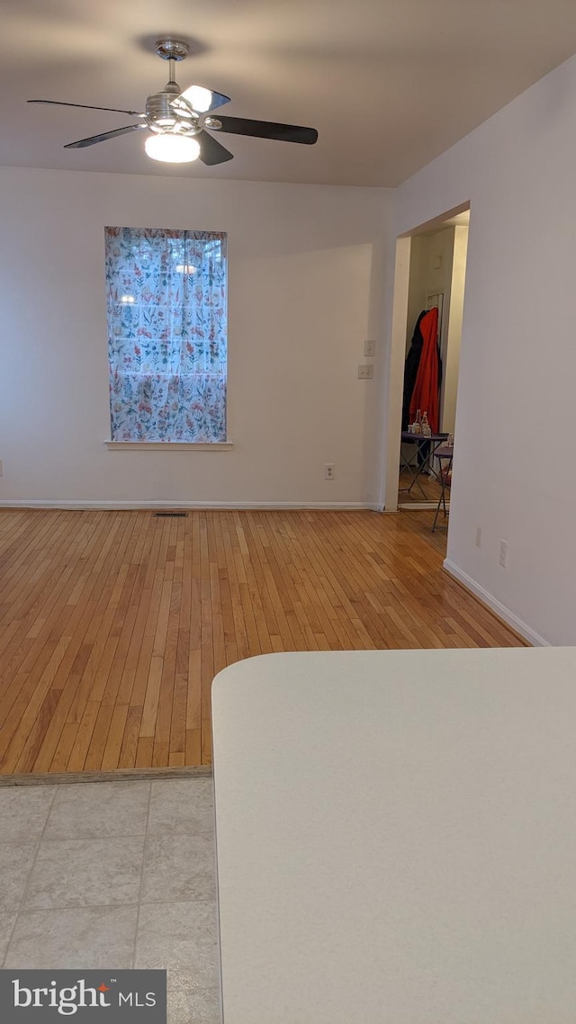 empty room featuring ceiling fan and light hardwood / wood-style flooring