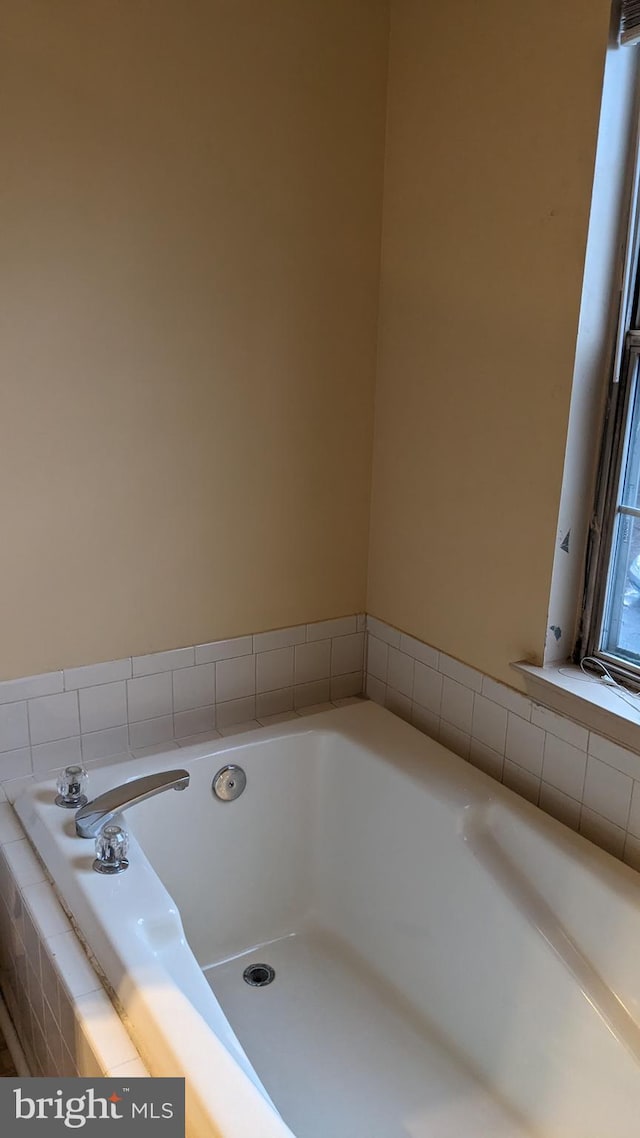 bathroom featuring a relaxing tiled tub