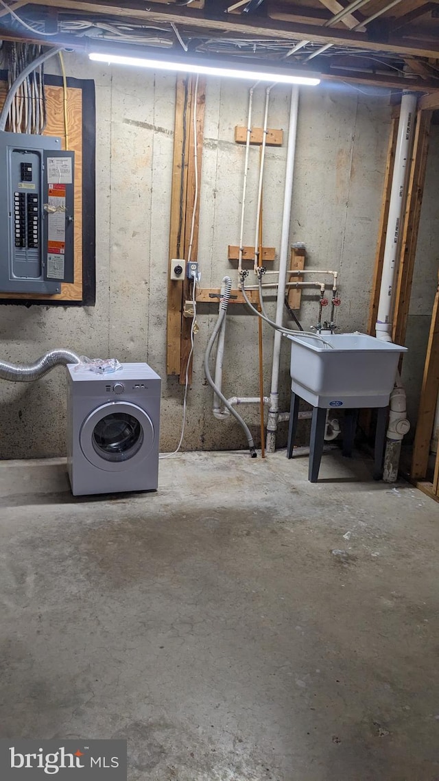 basement with electric panel, washer / dryer, and sink