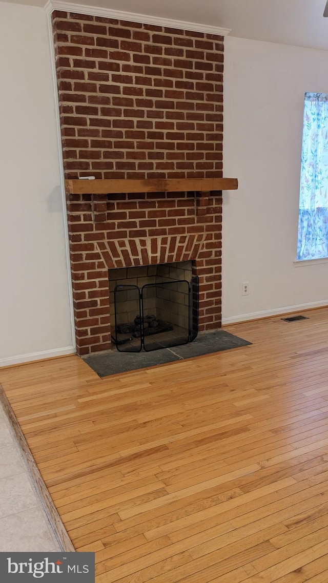 details with wood-type flooring and a brick fireplace