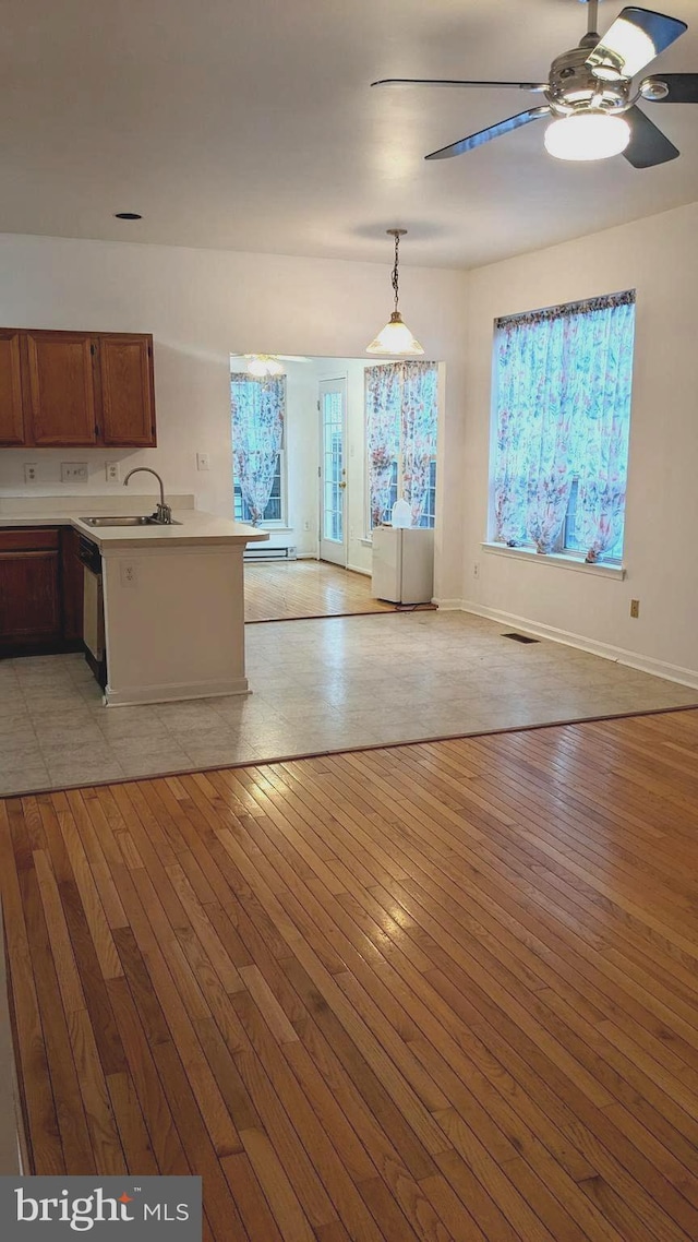 interior space with ceiling fan, sink, and light hardwood / wood-style floors