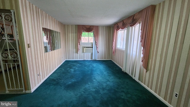 unfurnished room featuring dark carpet, cooling unit, and a textured ceiling