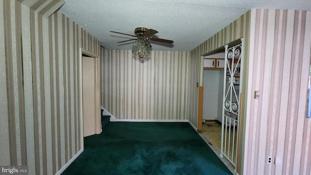 carpeted empty room with ceiling fan and a textured ceiling