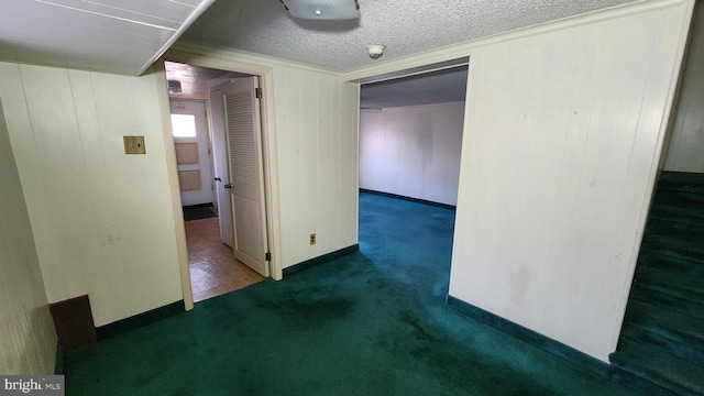 carpeted empty room featuring a textured ceiling