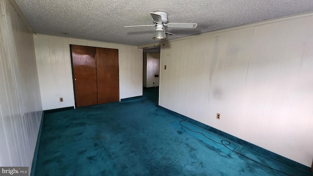 unfurnished bedroom with ceiling fan, a closet, a textured ceiling, and dark colored carpet