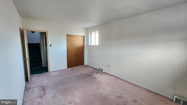 unfurnished bedroom with a closet and light carpet