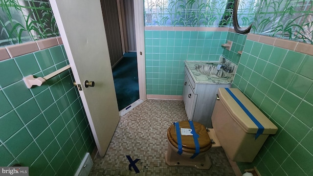 bathroom featuring tile walls, vanity, tile patterned flooring, and toilet