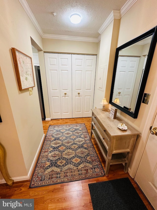 hall featuring ornamental molding, a textured ceiling, and hardwood / wood-style flooring