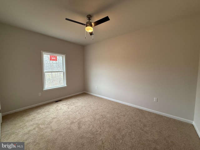 unfurnished room with ceiling fan and carpet