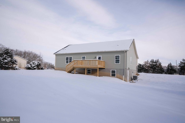 snow covered rear of property featuring a wooden deck