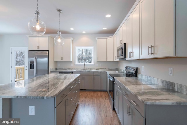 kitchen featuring appliances with stainless steel finishes, a center island, and gray cabinetry