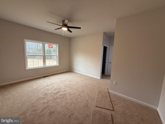 empty room with ceiling fan and light carpet