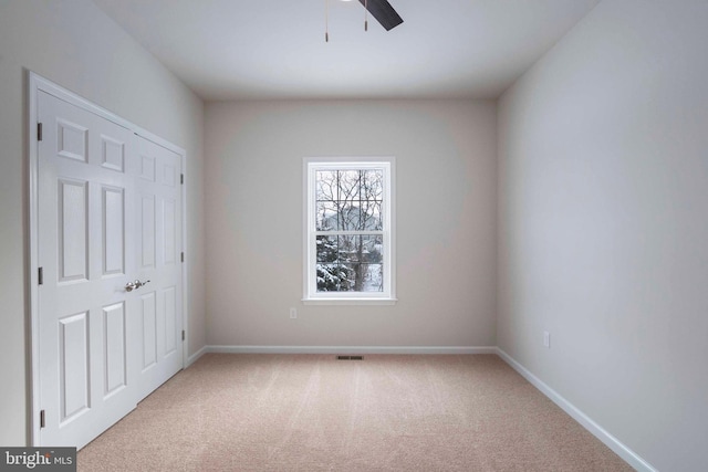 unfurnished bedroom with ceiling fan and light colored carpet