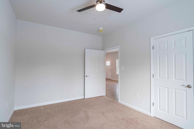 unfurnished bedroom with ceiling fan and light colored carpet