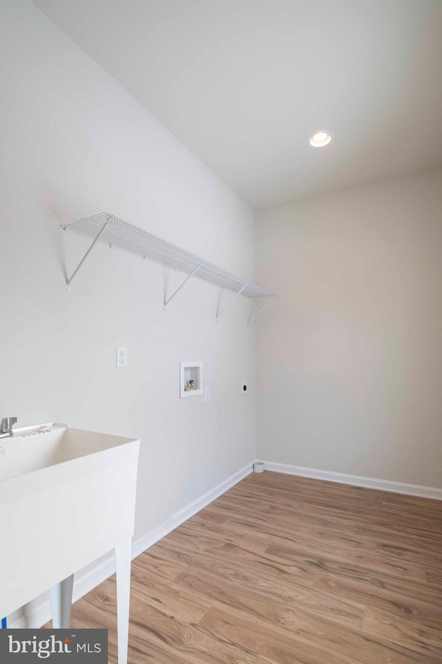 laundry area with hardwood / wood-style flooring, sink, electric dryer hookup, and hookup for a washing machine