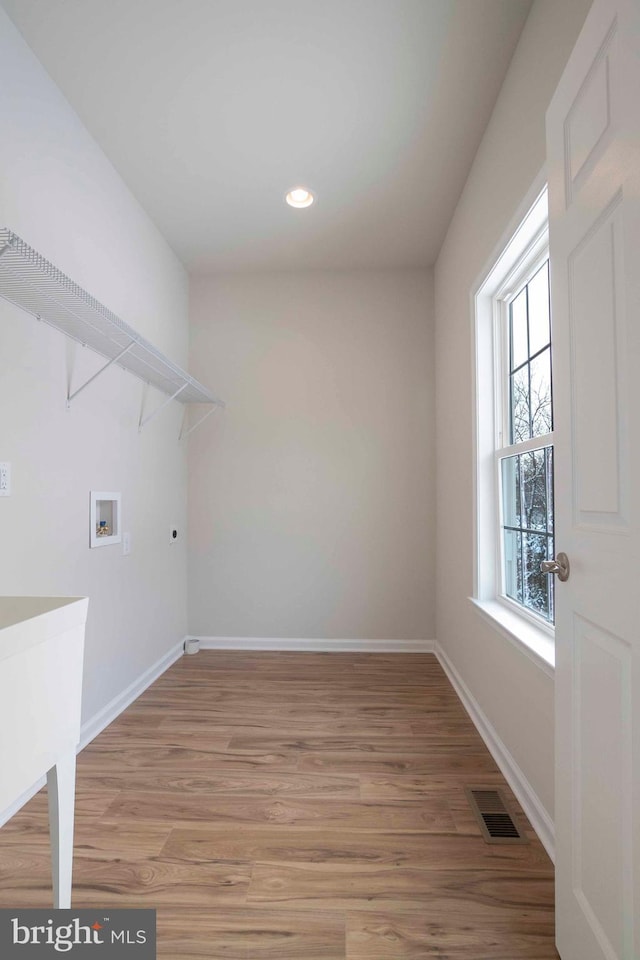 clothes washing area with hookup for a washing machine, wood-type flooring, sink, and electric dryer hookup