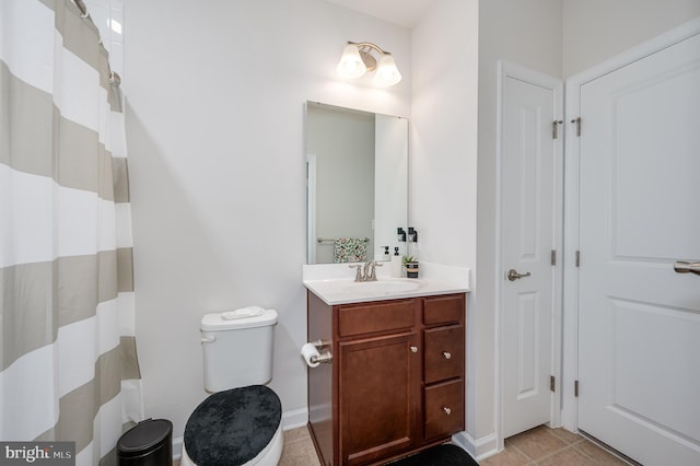 bathroom with tile patterned flooring, vanity, and toilet